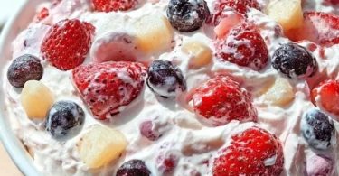 Delicious berry cheesecake topped with fresh berries and a creamy layer