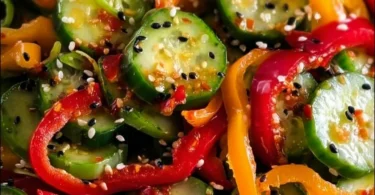 Colorful Cucumber Sweet Pepper Salad garnished with herbs.