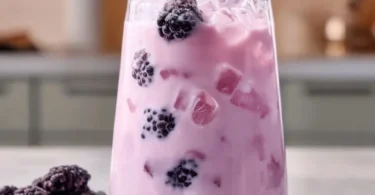 Homemade blackberry coconut drink served in a glass with ice and fresh berries
