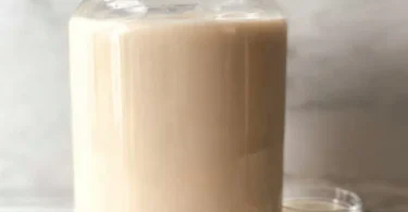A glass of horchata topped with cinnamon and ice, showcasing the traditional beverage.